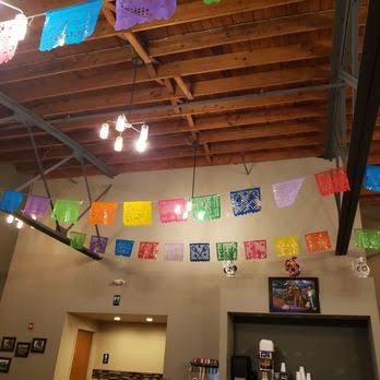 Colorful papel picado banners strung across the wood-beamed ceiling.